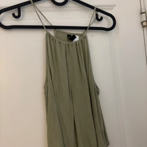 Olivgrön ribbad linnetopp från H&M  - Säljer en olivgrön ribbad linnetopp från H&M Divided. Toppen har tunna axelband och en luftig passform, perfekt för varma dagar. Enkel och stilren design som passar till mycket. 🌿