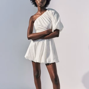 Vit oneshoulder klänning - Säljer denna vita oneshoulder klänning med en puffig ärm och lätt rynkad design. Använt 1 gång så väldigt bra skick perfekt för studenten strl 34💓💓