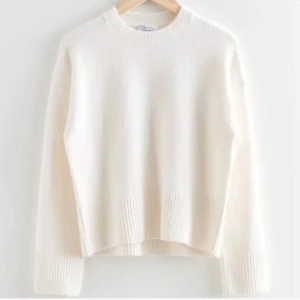 Vit stickad tröja - Säljer en stilren vit stickad tröja med rund hals och långa ärmar. Tröjan har ribbade detaljer vid ärmslut och nederkant, vilket ger en klassisk look. Perfekt för kyligare dagar. Har två små maskor men inget man tänker på💕