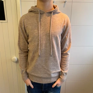 Merinoull Hoodie - En riktigt snygg Merinoull Hoodie i en beige färg! Storlek M. Använd max 3 gånger, inga defekter eller tecken på användning! Hör av dig vid intresse eller minsta fundering!
