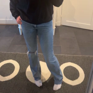 Ljusblå jeans med slitningar - Snygga ljusblå jeans med slitningar på knäet. De har en klassisk straight passform och är perfekta för en avslappnad stil. Kombinera med en hoodie eller t-shirt för en cool look. Storlek 36