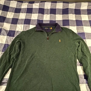 Halfzip från Polo Ralph Lauren - Säljer en grön tröja från Polo Ralph Lauren med dragkedja. Storleken oklar men jag skulle säga att tröjan är i storleken (m) då den passar mig som är 183cm. 