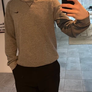 Nike Golf Sweatshirt  - Säljer en grå Sweatshirt från Nike Golf som är perfekt för träning, golf eller till vardags. Modellen är 177cm och 77kg. Hör av er vid frågor!