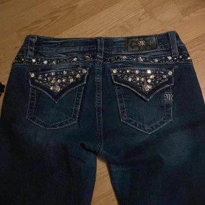 INTRESSEKOLL!!  - Miss me jeans med glittrande strassdetaljer på bakfickorna och längs linningen. De har en midwaist passform och en bootcut. Minimalt slitage på slutet av benen. KÖP INTE UTAN ATT KONTAKTA, VET INTE OM JAG VILL SÄLJA ÄN, KOM MED BUD!!!!