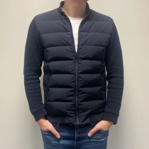 Cardigan från Woolrich - Säljer en stilren mörkblå cardigan från Woolrich. Jackan har en dragkedja framtill och långa ärmar. Perfekt året runt med sin quiltade design som håller värmen bra. Storlek L och i extremt bra skick! Nypris 5000+
