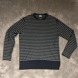 Randig tröja från Filippa K - Säljer en stilren randig tröja från Filippa K i blått och vitt. Tröjan är tillverkad av 50% bomull och 50% ull.