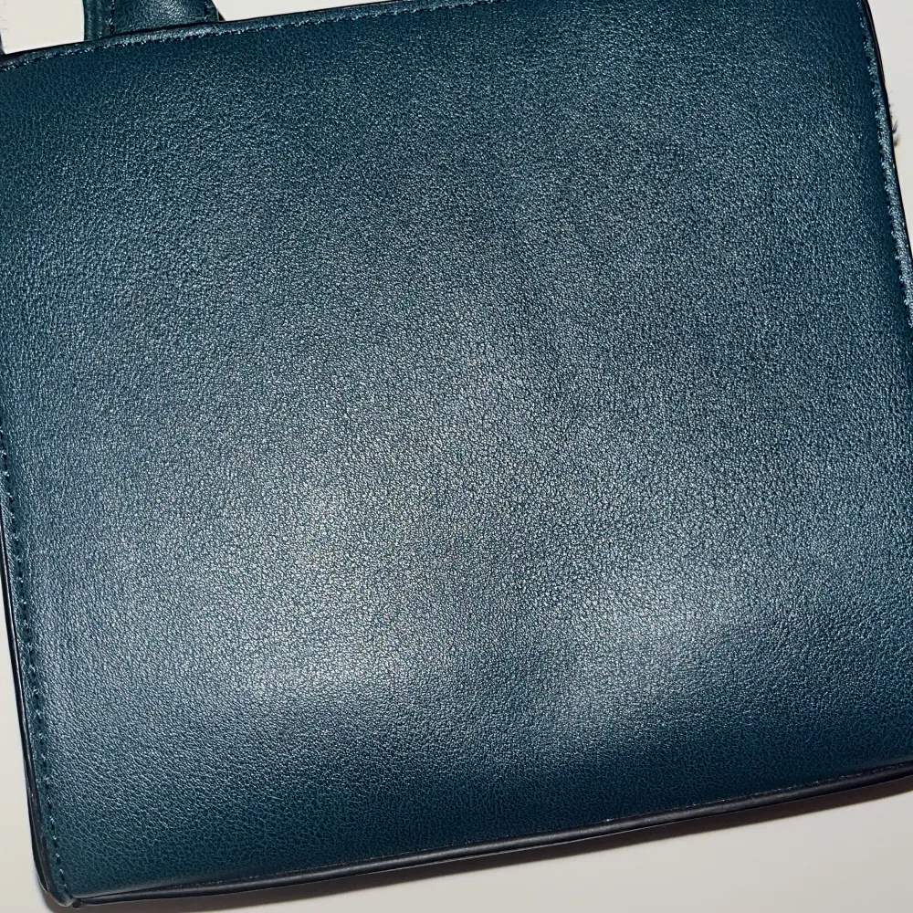 Snygg och stilren svart axelväska med justerbar rem och handtag. Perfekt för att bära dina nödvändigheter med stil. Väskan har en enkel och elegant design som passar till många olika tillfällen.. Laukut & Käsilaukut.