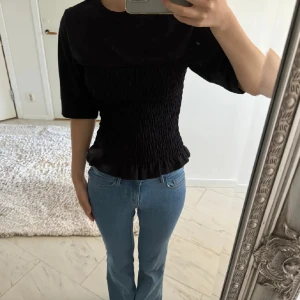 Svart topp med smock  - Säljer den trendiga tröjan från hm med smock detaljer, strl Xs men passar även som en S då den är stretchig , använd ett fåtal gånger nypris: 179kr