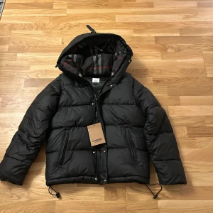 Svart pufferjacka från Burberry -  Svart Burberry jacka som även blir till väst storlek S helt ny pris kan diskuteras