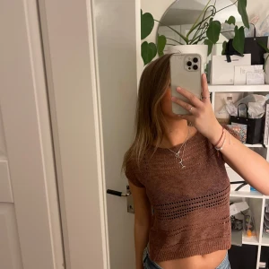 Orange stickad topp från United Colors of Benetton - Snygg orange stickad topp från United Colors of Benetton med korta ärmar och ett luftigt mönster.  Den har en avslappnad passform och är gjord i ett bekvämt material.