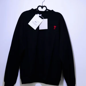 Ami Paris Sweatshirt - Helt ny Ami Paris Sweatshirt med ett märke på bröstet. Tröjan har långa ärmar och en klassisk passform. Perfekt för en stilren look. Finns fler storlekar i min profil😁