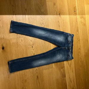 Blå jeans från Nudie Jeans - Snygga blå jeans från Nudie Jeans med en klassisk femficksdesign. De har en slim passform och är tillverkade i slitstarkt denim. Perfekta för en stilren look.