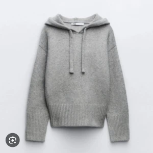 Grå hoodie i stickat material - Mysig grå hoodie med ribbade muddar och luva. I nyskick då den knappt är använd