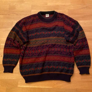 Grandpa sweater/stickad tröja - Säljer en färgglad och mönstrad stickad tröja. Tröjan har ett unikt geometriskt mönster i rött, orange, grönt och blått. En skit snygg grandpa sweater som sitter Oversize. Den är använd men super bra skick. Perfekt för vintern och hösten. Köpt på depop för ca 1200. Priset kan alltid diskuteras.
