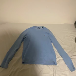 Ljusblå tröja från Gant - Säljer en stilren ljusblå tröja från Gant i premium bomull. Tröjan har en liten logotyp på bröstet och är perfekt för en avslappnad look. Den har långa ärmar och en rund halsringning. Passar till M och S!