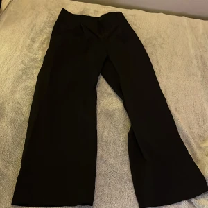 Svarta byxor från Shein - Snygga svarta byxor från Shein med hög midja och vida ben. Perfekta för en stilren look. Byxorna har en knapp och dragkedja framtill.