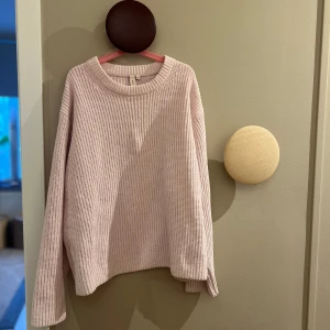 Beige stickad tröja från Nelly - Mysig Rosa stickad tröja från Nelly i storlek XS. Perfekt för kyliga dagar med sin ribbade design och långa ärmar. En stilren och bekväm tröja för alla tillfällen. Använd fåtal ggr.