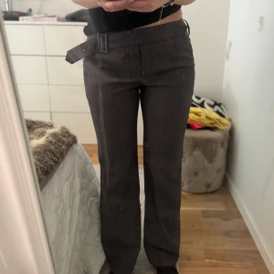 Randiga kostymbyxor 🩷🩷 - Såå snygga gråa kostymbyxor med tunna rosa ränder🩷🩷 Bältet är en så fin detalj! jag är S/M och 170 cm som referens <3 skriv om ni har frågor <33  (säljer även massa stickade tröjor från &otherstories, in och kika!!🧚🧚)