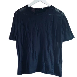 Svart t-shirt från Samsøe Samsøe stl XS - Snygg svart t-shirt från Samsøe Samsøe med korta ärmar. Genomskinliga/transpersenta delar och Oversized storlek S. Slitage på tyg efter tvätt men inga hål/fläckar.
