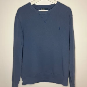 Ralph Lauren tröja - Hej! Säljer denna riktigt snygga blå tröjan från Polo Ralph Lauren! Tröjan är i ett mycket fint skick utan några defekter. 😊köpt för 2000kr förra året och har blivit sparsamt använd! Tröjan har en fin blå färg med ett broderat märke i färgen marinblå. Storlek medium och passar modellen på bilden bra som är 180cm och väger 67kg. Mitt pris är endast 500kr! Har inget kvitto kvar då det var ett tag sedan den var köpt. Skriv vid minsta intresse! Mvh DC🔹