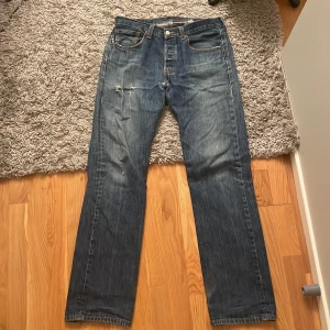 Levis 501 - Säljer ett par Levis med storlek 33 i midjan och 34 i längden. Som bilderna visar är de någorlunda trasiga och kan behöva små små reparationer beroende på hur kräsen man är:) 21,5cm i benöppning 🙏 