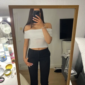 Vit offshoulder topp - Snygg vit offshoulder topp som är croppad och perfekt för en trendig look. Toppen har en tight passform och är tillverkad i ett mjukt material som ger en bekväm känsla.