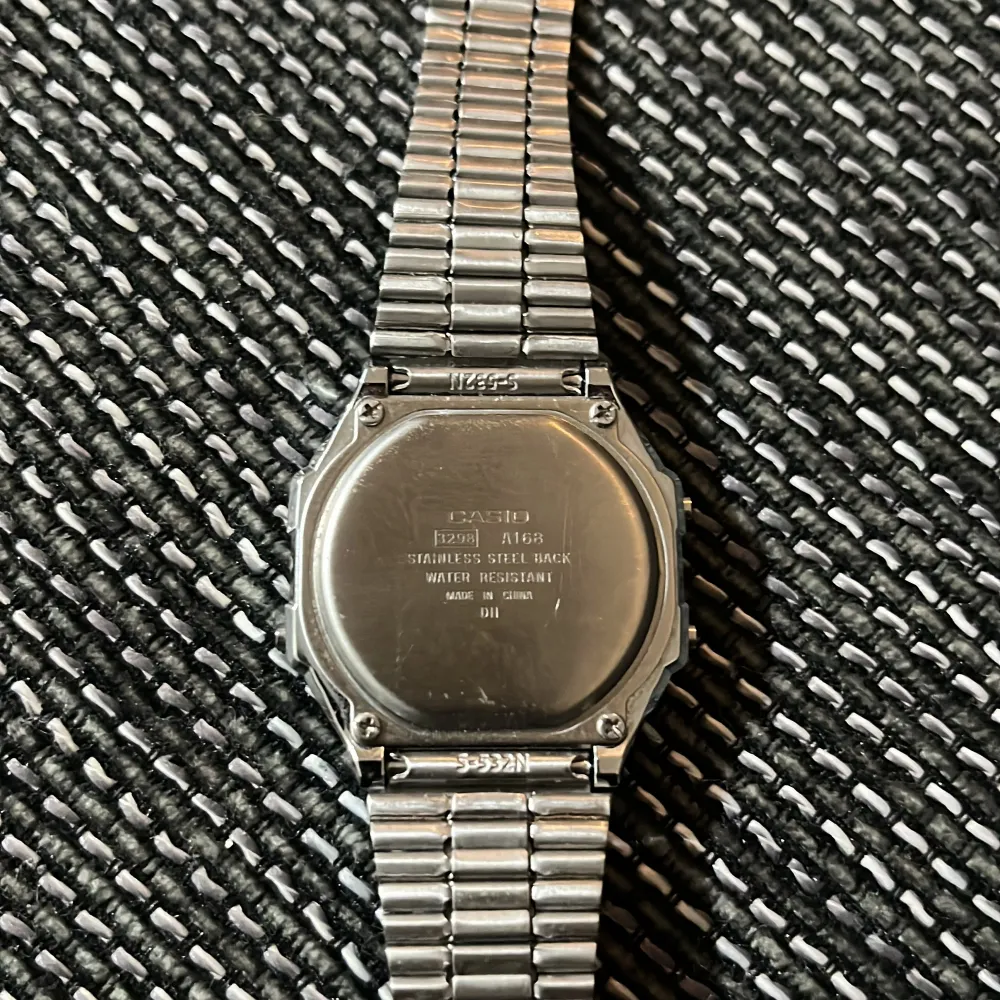 Säljer en klassisk Casio digital klocka med silverfärgad stållänk och rektangulär urtavla. Klockan har funktioner som alarm, belysning och stoppur. Perfekt för en retrostil! 🕒. Asusteet.
