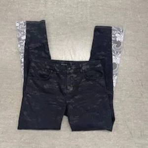 Svarta jeans med mönstrade detaljer - Snygga svarta jeans med unika mönstrade detaljer på insidan av benen. Perfekta för att ge din outfit en extra edge. Klassisk femficksdesign och knappgylf. Köota secondhand, omsydda av mined uf.