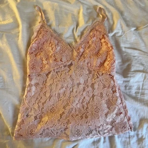 Rosa spetslinne - Säljer ett rosa spetslinne med smala axelband och v-ringning. Man langa det som de är eller under en annan tröja🩷