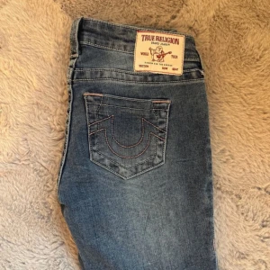 Blå jeans från True Religion - Snygga blå jeans från True Religion med bootcut-stil. De har klassiska fickor och en tydlig logga på bakfickan. Passar till allt. Endast använda en gång. Nypris 1500kr