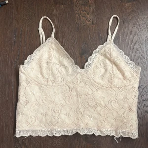 spetslinne från BikBok - Säljer ett fint beige spetslinne från BikBok med justerbara axelband och vacker spetsdetalj. Passar bra till både vardag och fest. Hör av er för fler bilder eller andra frågor💗💗 (bild 3 lånad från tidigare säljare)
