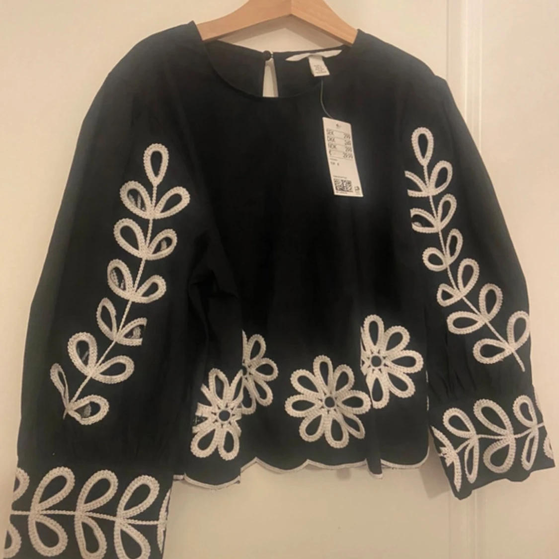 Svart blus med vit broderad design