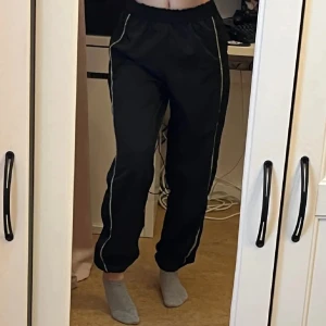 Svarta träningsbyxor med strass detaljer - Snygga svarta träningsbyxor med strass/diamant detaljer längs sidorna. Byxorna har en elastisk midja och en stretchig passform. Perfekta för en avslappnad stil eller träning. Använd 1 gång, strl XS