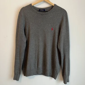 Grå tröja från Polo Ralph Lauren - Snygg grå tröja från Ralph lauren. Modellen är 180 cm lång och väger 65 kg