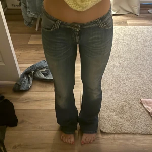 Blå jeans från Lee - Säljer ett par snygga blå jeans från Lee i storlek S. De är lågmidjade och har en straight passform. Jeansen är i bra skick förutom en liten fläck på knät från en penna, inte testat att ta bort 