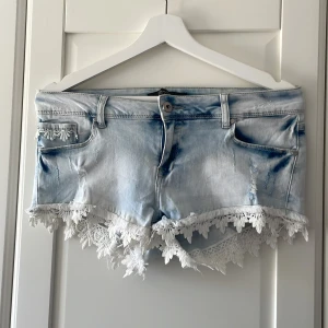 Korta jeansshorts i strl ca S - Korta och lågmidjade jeansshorts med spetskant, köpta i Spanien för flera år sen. Står storlek 42 men skulle säga att de mer är en 36