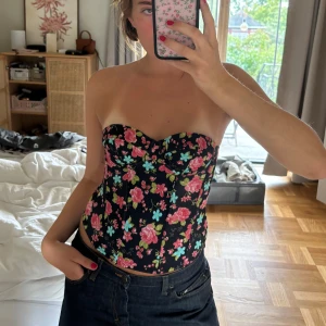 Korsett topp storlek S - Svart korsett topp med blommor från H&M i storlek S. Superfint skick och finns inte att få tag i någonstanns💗