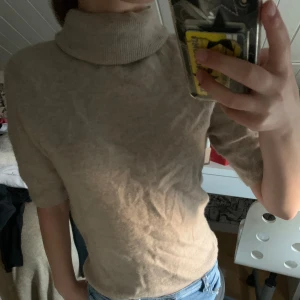 Beige polotröja - Säljer en snygg beige polotröja i storlek S. Tröjan är perfekt för höst och vår med sin mjuka och bekväma passform. Den har korta ärmar och en hög polokrage som håller dig varm och stilren. Passar både till vardags och lite finare tillfällen. Köp nu eller ge ett bud! 💛