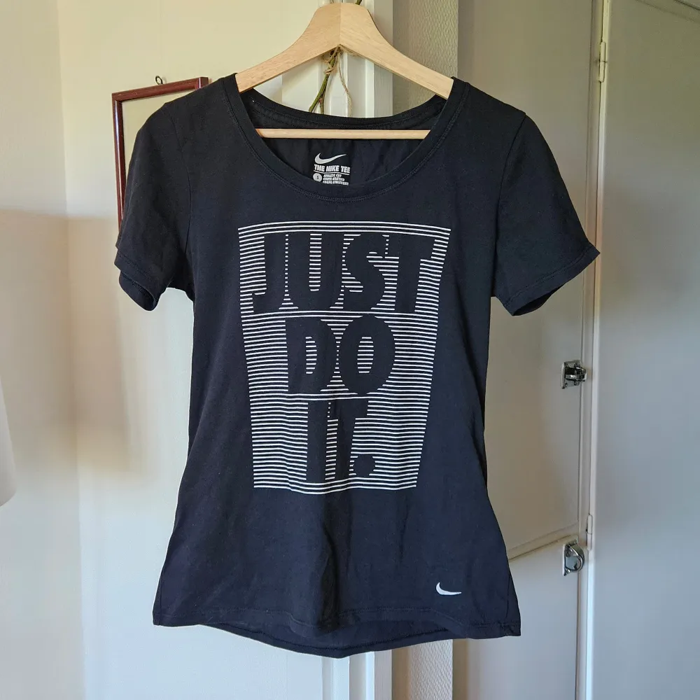 En svart t-shirt med tryck framtill; just do it. Dri-fit material. Toppen är i bra skick!. Sportswear.