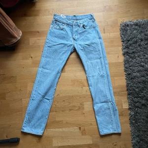 Levis 501 jeans i ljusblå denim - Säljer ett par klassiska Levis 501 jeans i ljusblå denim. De är i perfekt skick, då de endast är använda ca. 10 gånger. Perfekta för en casual look! Passar både till vardags och fest. Köp direkt eller ge prisförslag 💙
