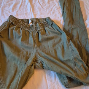 Gröna byxor från G - Säljer ett par gröna byxor från märket G i storlek M. Byxorna har en elastisk midja och verkar vara väldigt bekväma. Perfekta för en avslappnad dag eller för att bara chilla hemma. De är i bra skick och redo för en ny ägare!