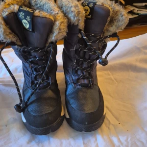 Svarta vinterkängor från Hummel - Säljer ett par svarta vinterkängor från Hummel i storlek 37. De är fodrade med mysig päls och har snörning framtill. Perfekta för kalla vinterdagar! Kängorna är i bra skick och redo för en ny ägare. Köp direkt eller ge prisförslag!