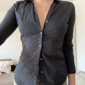 Vintage figursydd skjorta - Figursydd bomullsskjorta från H&M (köpt secondhand). Kramar om kroppen på perfekt ställen och ger fin figur 🤍Storlek 40 men definitivt mer en 36/38. Kortare ärm. Min allra favoritskorta men tyvärr för liten nu…  Mitt pris: 150kr
