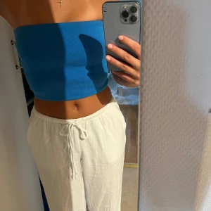 Blå ribbad tubtopp - Säljer en snygg blå ribbad tubtopp. Perfekt för sommaren och festliga tillfällen. Toppen är tight och croppad, vilket ger en trendig look. Passar bra till både jeans och kjol. Köp direkt eller ge prisförslag 💙