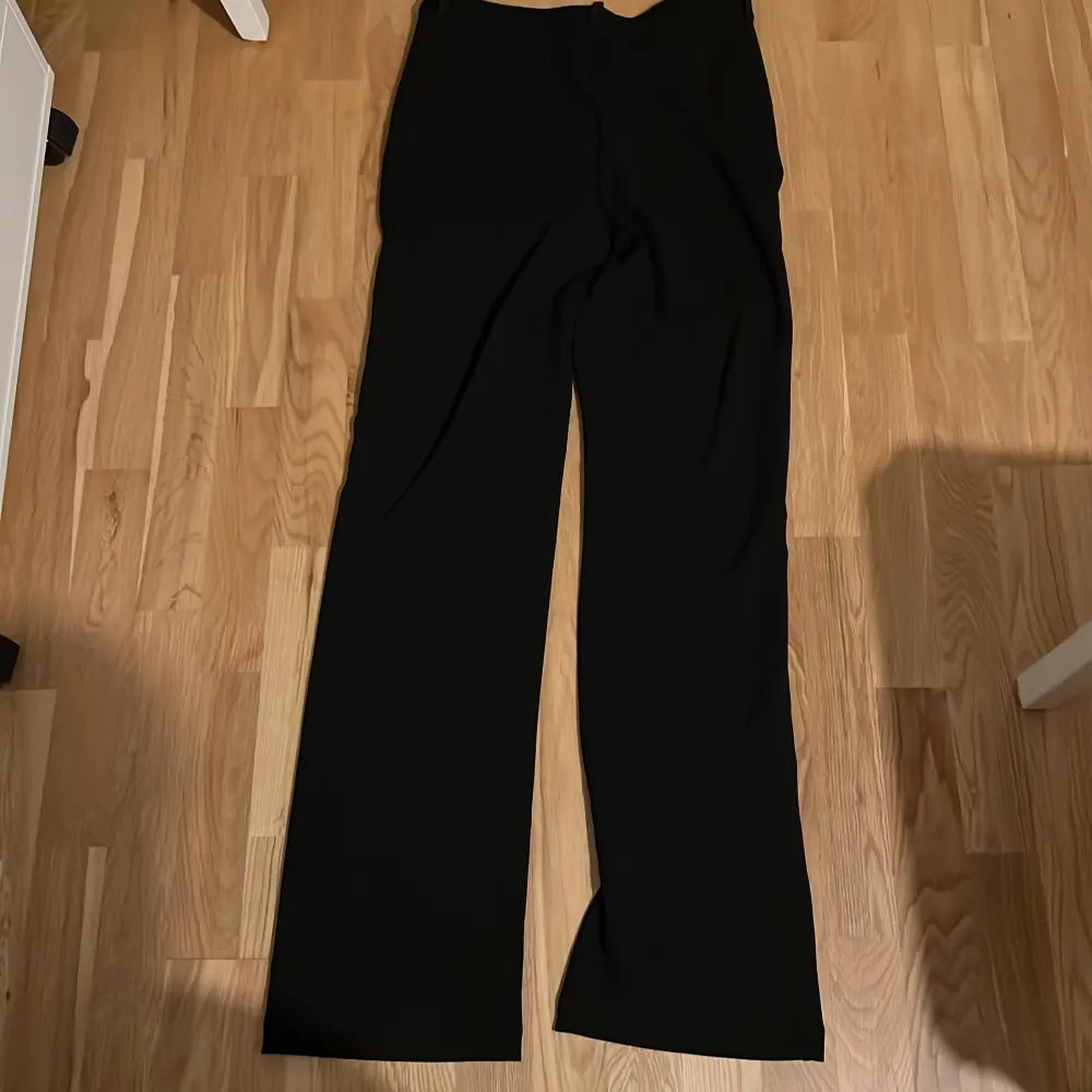 Snygga svarta byxor från Vero Moda med en klassisk design. De har en rak passform och är perfekta för en stilren look. Byxorna är tillverkade i ett mjukt material som ger en bekväm känsla hela dagen.. Farkut & Housut.