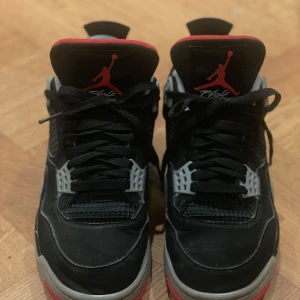 Air Jordan 4 Retro “Bred”  - Dessa Jordan 4 Retro ”bred” är en tidlös model som är den perfekta blandningen av stil och komfort. De är svarta, röda och grå och i jättefint skick. Jag har använt dem runt 10 gånger, men de är lite lätt creasade. Annars har de inga synliga fläckar eller defekter.