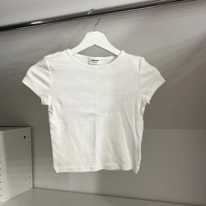 Vit ribbad t-shirt från Kappahl - Säljer en vit ribbad t-shirt från Kappahl i storlek 146/152. Den har en  rund hals och korta ärmar.