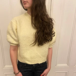 Gul stickad tröja - Säljer en söt gul stickad tröja med korta ärmar och en bekväm passform. Tröjan har en enkel design som gör den lätt att matcha med olika outfits!!
