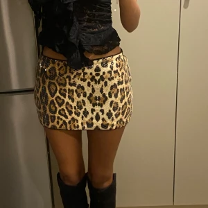 Leopardmönstrad glittrig kortkjol - Snygg leopardmönstrad kortkjol med glittriga detaljer. Perfekt för en kväll ute eller när du vill sticka ut. Kjolen har en tight passform och är ett måste för garderoben.