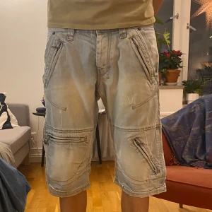 Jeansshorts - Ljusblå jeansshorts med dragkedjor och snygga detaljer🕺bra skick!